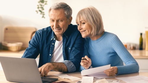 Older couple around a laptop