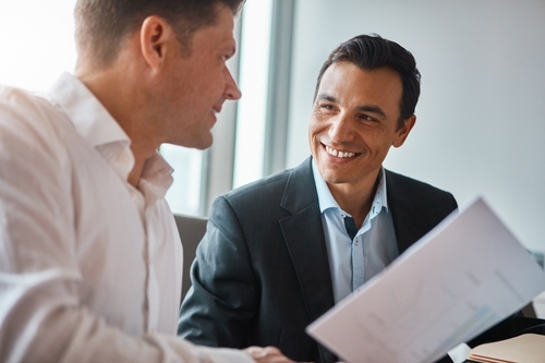 Two men discussing a form